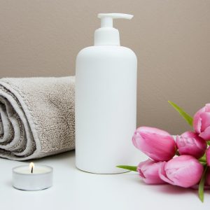 Photo détente Séverine EMMIYAN white plastic pump bottle beside pink tulips and gray towel